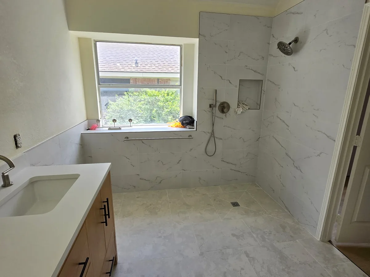 Curbless accessible shower with marble look tile walls
