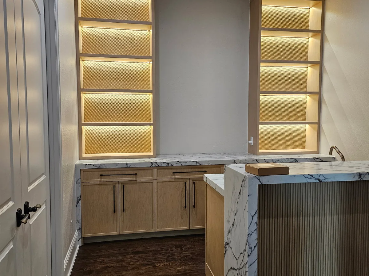 Marble vanity with backlit shelving in a remodeled bath