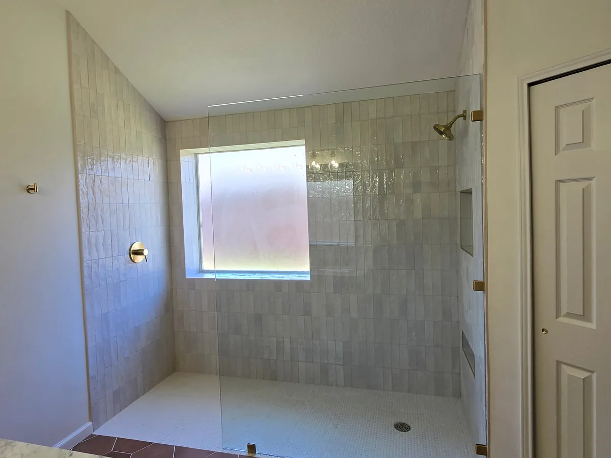Walk in shower with vertical tile and frosted window